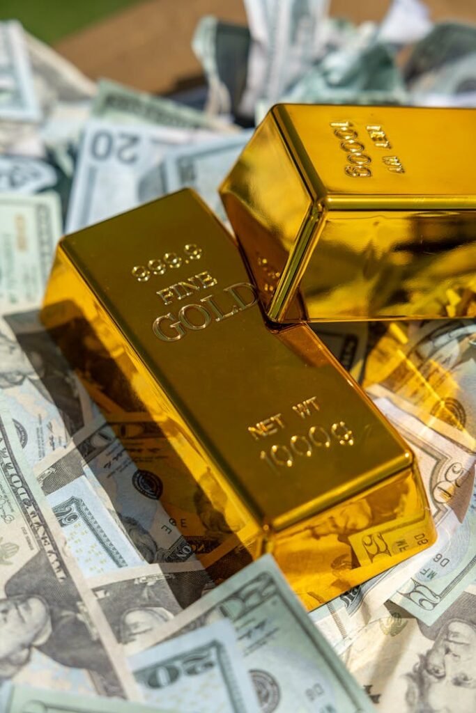 Close-up of gold bars atop US currency, symbolizing wealth and investment.